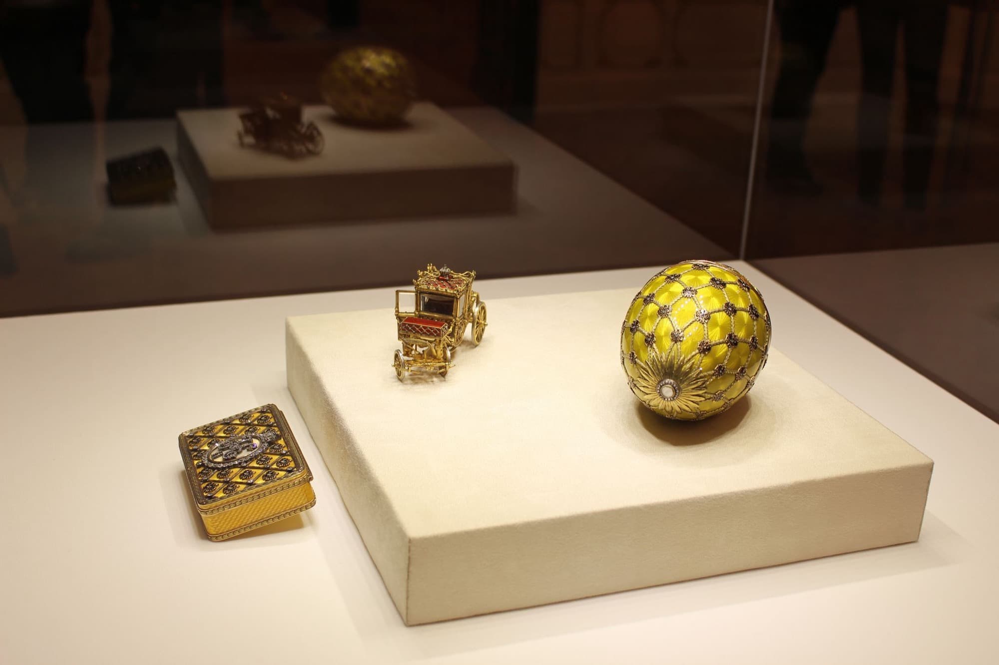 The egg beside its surprise: a miniature of the imperial coronation coach, under ten centimeters long, with opening doors, a folding step, and tiny springs so it rocks like the real thing. Photo by Guy Fawkes, CC BY-SA 2.0.