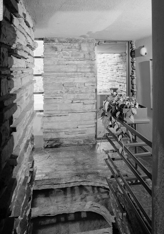 Interior stair landing: the house is woven around the rock it sits on · HABS, public domain