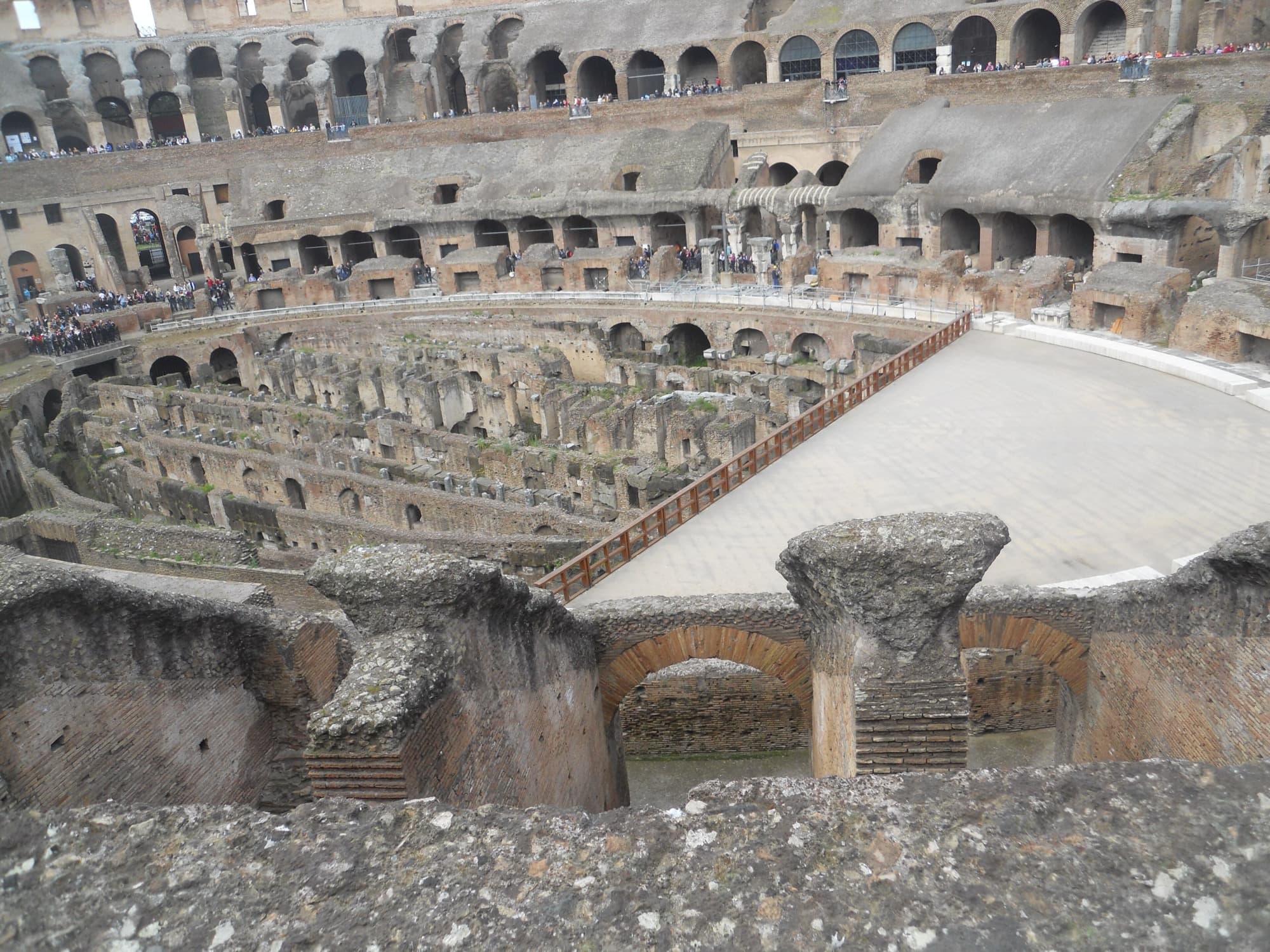 The arena floor is gone, exposing the hypogeum: the underground maze of tunnels, cages and lift shafts beneath the fighting surface. Photo by Erik Drost, CC BY 2.0.